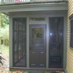 Four track vertical sliding vinyl windows with bronze aluminum framing